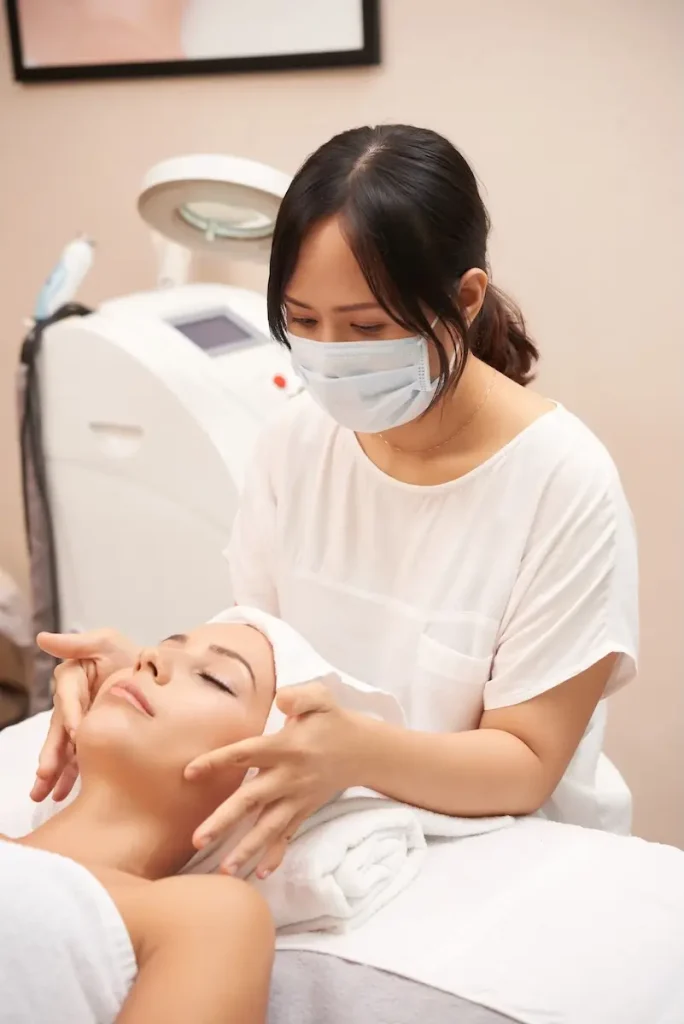 asian-cosmetician-giving-caucasian-client-face-massage